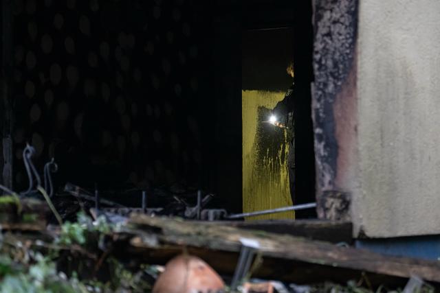 13 October 2025, Berlin: Police officers stand in a burnt-out apartment in Berlin-Neukoelln. Numerous people were injured in the fire. Photo: Fabian Sommer/dpa