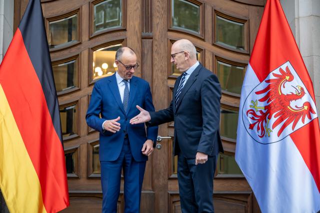 14 October 2025, Brandenburg, Potsdam: German Chancellor Friedrich Merz (L) is welcomed by Dietmar Woidke, Minister President of Brandenburg, at the cabinet meeting in front of the State Chancellery of Brandenburg. Photo: Michael Kappeler/dpa