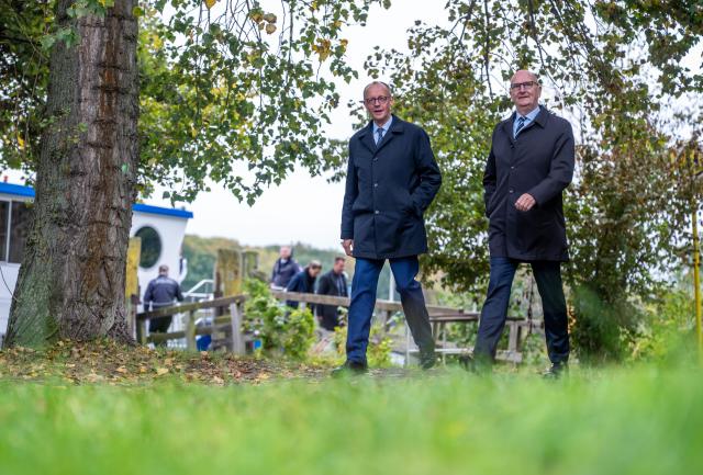 14 October 2025, Brandenburg, Potsdam: German Chancellor Friedrich Merz (L) walks next to Dietmar Woidke, Minister President of Brandenburg, during his inaugural visit to Brandenburg. Photo: Michael Kappeler/dpa