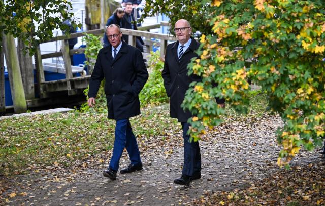 14 October 2025, Brandenburg, Potsdam: German Chancellor Friedrich Merz (L) walks next to Dietmar Woidke, Minister President of Brandenburg, during his inaugural visit to Brandenburg. Photo: Britta Pedersen/dpa