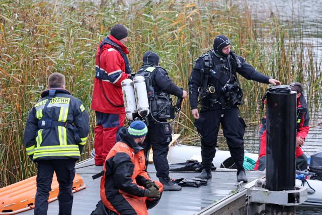 14 October 2025, Mecklenburg-Western Pomerania, Guestrow: Divers are preparing to search for missing eight-year-old Fabian at the Inselsee lake. A child's body has been found after a four-day search for a missing 8-year-old in northern Germany, with police suspecting a criminal offence in the case. Photo: Bernd Wüstneck/dpa