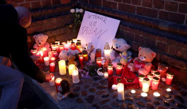 14 October 2025, Mecklenburg-Western Pomerania, Klein Upahl: Participants place candles and mementos in front of St. Mary's Church after the body of a child was found in a forest near Guestrow. Photo: Bernd Wüstneck/dpa