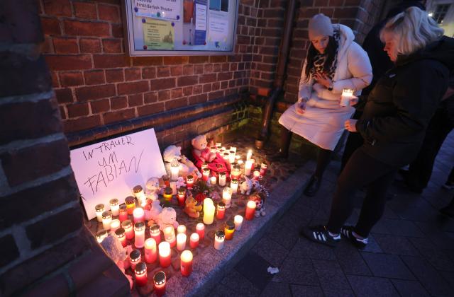 14 October 2025, Mecklenburg-Western Pomerania, Klein Upahl: Participants place candles and mementos in front of St. Mary's Church after the body of a child was found in a forest near Guestrow. Photo: Bernd Wüstneck/dpa