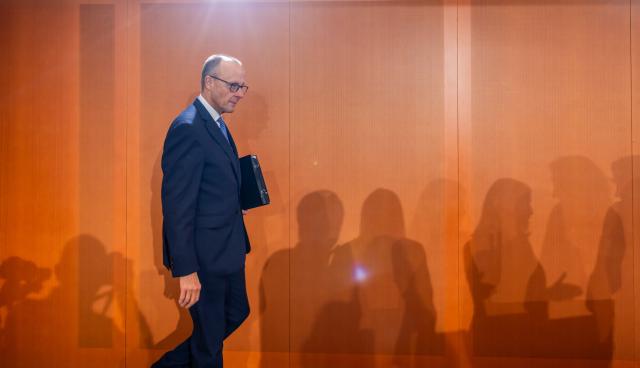 15 October 2025, Berlin: German Chancellor Friedrich Merz enters the hall at the beginning of the German Cabinet meeting in the Federal Chancellery, while the silhouettes of the cabinet members are silhouetted on the wall. Photo: Michael Kappeler/dpa