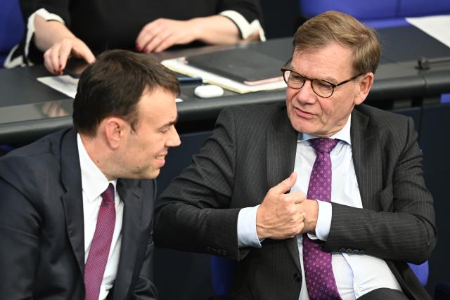 15 October 2025, Berlin: Johann Wadephul (R), German Foreign Minister, speaks to Nils Schmid, Parliamentary State Secretary at the German Ministry of Defense, during the 33rd plenary session of the 21st legislative period at the German Bundestag. Photo: Niklas Graeber/dpa