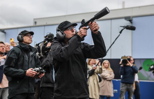 15 October 2025, North Rhine-Westphalia, Duesseldorf: Police officers aim a net launcher at a drone during the North Rhine-Westphalia police presentation of their drone defense capabilities. Photo: Oliver Berg/dpa