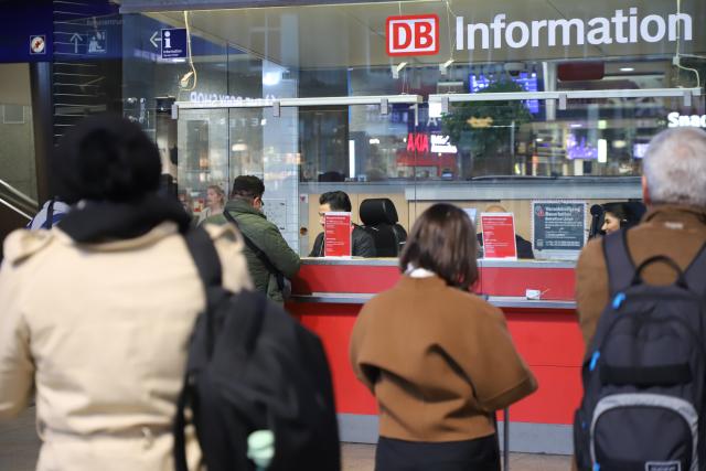 15 October 2025, North Rhine-Westphalia, Cologne: Travelers get advice at a DB Information info point at Cologne Central Station. A defective signal box has led to massive problems in rail traffic around Cologne. Photo: Sascha Thelen/dpa