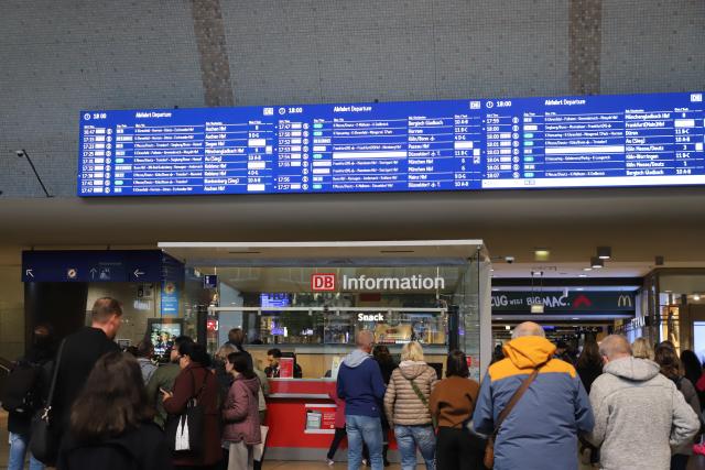 15 October 2025, North Rhine-Westphalia, Cologne: Passengers stand in front of a display board at Cologne Central Station. A defective signal box has led to massive problems in rail traffic around Cologne. Photo: Sascha Thelen/dpa