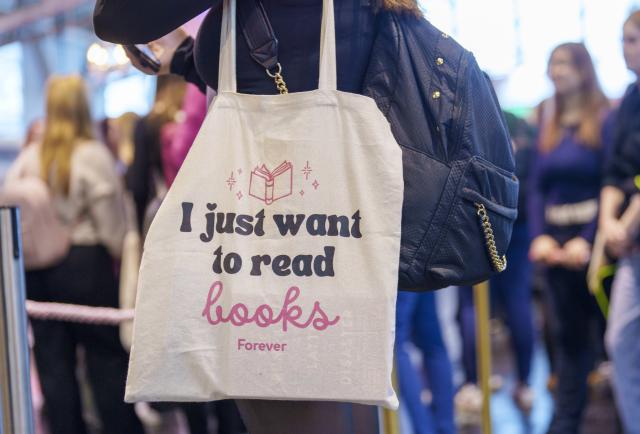 16 October 2025, Hesse, Frankfurt/Main: A trade visitor carries an "I just want to read books Forever" bag in the exhibition hall for New Adult (NA) literature. A separate area in Hall 1.2. is dedicated to the New Adult (NA) literature scene. The "New Adult" genre benefits greatly from its popularity on social media platforms such as TikTok ("BookTok"). Guest of Honour at the 77th Frankfurter Buchmesse (15-19 October 2025) is the Philippines. October 15 - 18, 2025 is reserved for trade visitors, the remaining days for all interested parties. Photo: Andreas Arnold/dpa