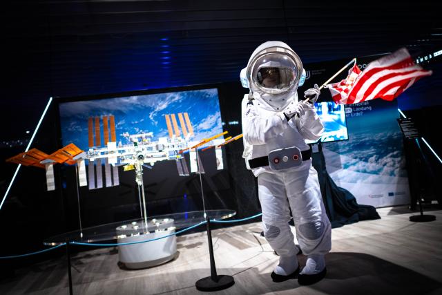 17 October 2025, Bremen: An astronaut waves a Bremen flag in the "Space Hub" exhibition. The exhibition can be seen in the former Kaufhof building until the end of November. Two events are taking place in Bremen in November: the Space Tech Expo, Europe's largest trade fair for space technology and engineering, and the European Space Agency (ESA) Ministerial Council Conference. Photo: Sina Schuldt/dpa