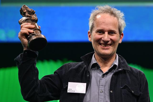 17 October 2025, Hesse, Frankfurt/Main: German illustrator Jens Rassmus holds the Momo trophy during the German Youth Literature Award 2025 ceremony at the 77th Frankfurter Book Fair. Photo: Arne Dedert/dpa