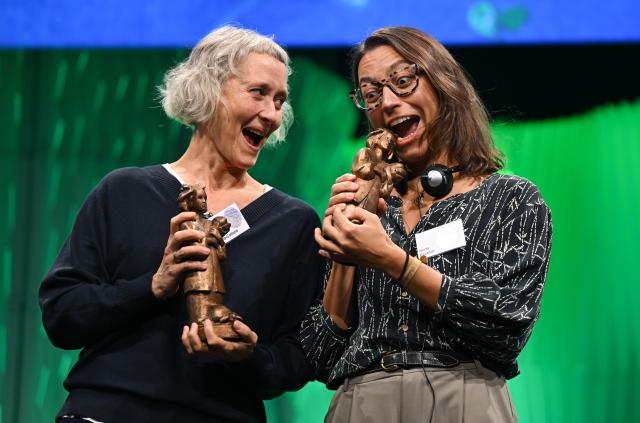 17 October 2025, Hesse, Frankfurt/Main: German translator Stefanie Kuballa-Cottone (L) and Spanish author Berta Paramo celebrate the Momo Trophy during the German Youth Literature Award 2025 ceremony at the 77th Frankfurter Book Fair. Photo: Arne Dedert/dpa