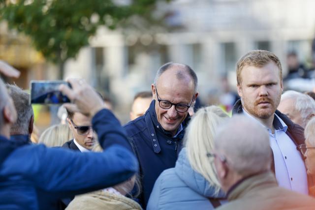 18 October 2025, North Rhine-Westphalia, Meschede: German Chancellor Friedrich Merz is greeted by citizens at the citizens' talk. Merz is from from the Sauerland region. Photo: Christoph Reichwein/dpa