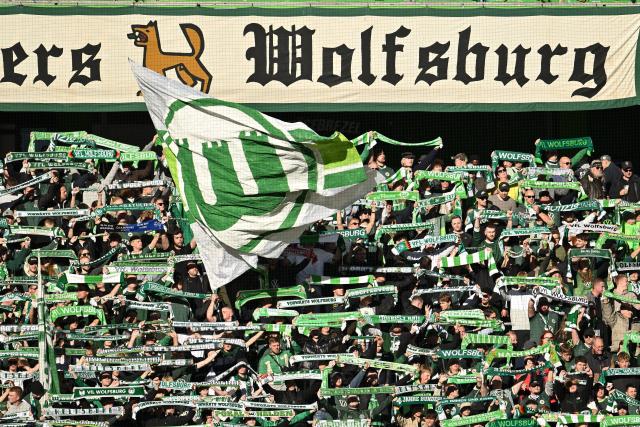 18 October 2025, Lower Saxony, Wolfsburg: Wolfsburg fans cheer in the stands with their scarves prior to the start of the German Bundesliga soccer match between VfL Wolfsburg and VfB Stuttgart at Volkswagen Arena. Photo: Swen Pförtner/dpa - WICHTIGER HINWEIS: Gemäß den Vorgaben der DFL Deutsche Fußball Liga bzw. des DFB Deutscher Fußball-Bund ist es untersagt, in dem Stadion und/oder vom Spiel angefertigte Fotoaufnahmen in Form von Sequenzbildern und/oder videoähnlichen Fotostrecken zu verwerten bzw. verwerten zu lassen.