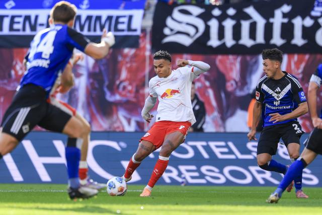 18 October 2025, Saxony, Leipzig: Leipzig's Antonio Nusa (C) and Hamburger's Noah Katterbach (R) battle for the ball during the German Bundesliga soccer match between RB Leipzig and Hamburger SV at Red Bull Arena. Photo: Jan Woitas/dpa - WICHTIGER HINWEIS: Gemäß den Vorgaben der DFL Deutsche Fußball Liga bzw. des DFB Deutscher Fußball-Bund ist es untersagt, in dem Stadion und/oder vom Spiel angefertigte Fotoaufnahmen in Form von Sequenzbildern und/oder videoähnlichen Fotostrecken zu verwerten bzw. verwerten zu lassen.