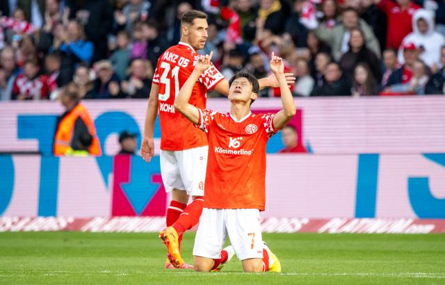 18 October 2025, Rhineland-Palatinate, Mainz: Mainz's Jae-Sung Lee (R) celebrates scoring his side's first goal next to teammate Dominik Kohr during the German Bundesliga soccer match between FSV Mainz 05 and Bayer Leverkusen at Mewa Arena. Photo: Torsten Silz/dpa - WICHTIGER HINWEIS: Gemäß den Vorgaben der DFL Deutsche Fußball Liga bzw. des DFB Deutscher Fußball-Bund ist es untersagt, in dem Stadion und/oder vom Spiel angefertigte Fotoaufnahmen in Form von Sequenzbildern und/oder videoähnlichen Fotostrecken zu verwerten bzw. verwerten zu lassen.