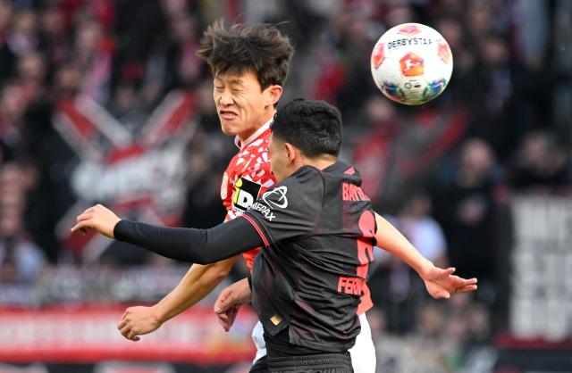 18 October 2025, Rhineland-Palatinate, Mainz: Leverkusen's Ezequiel Fernandez (R) and Mainz's Kaishu Sano battle for the ball during the German Bundesliga soccer match between FSV Mainz 05 and Bayer Leverkusen at Mewa Arena. Photo: Torsten Silz/dpa - WICHTIGER HINWEIS: Gemäß den Vorgaben der DFL Deutsche Fußball Liga bzw. des DFB Deutscher Fußball-Bund ist es untersagt, in dem Stadion und/oder vom Spiel angefertigte Fotoaufnahmen in Form von Sequenzbildern und/oder videoähnlichen Fotostrecken zu verwerten bzw. verwerten zu lassen.