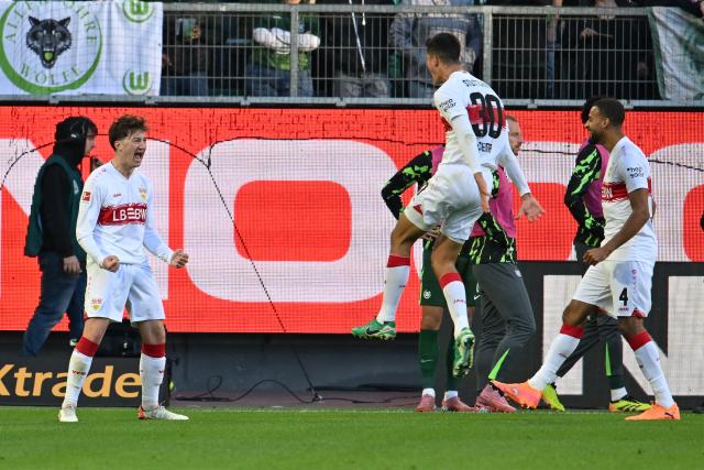 18 October 2025, Lower Saxony, Wolfsburg: Stuttgart's Angelo Stiller (L) celebrates scoring his side's third goal with teammates during the German Bundesliga soccer match between VfL Wolfsburg and VfB Stuttgart at Volkswagen Arena. Photo: Swen Pförtner/dpa - WICHTIGER HINWEIS: Gemäß den Vorgaben der DFL Deutsche Fußball Liga bzw. des DFB Deutscher Fußball-Bund ist es untersagt, in dem Stadion und/oder vom Spiel angefertigte Fotoaufnahmen in Form von Sequenzbildern und/oder videoähnlichen Fotostrecken zu verwerten bzw. verwerten zu lassen.