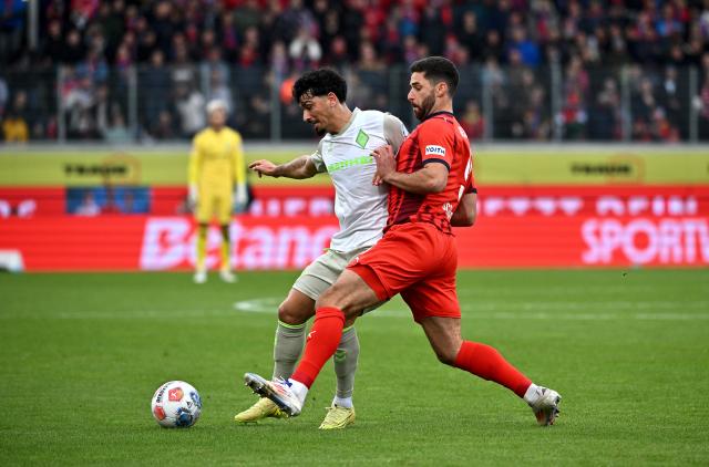 18 October 2025, Baden-Wuerttemberg, Heidenheim: Werder Bremen's Cameron Puertas (L) and Heidenheim's Stefan Schimmer battle for the ball during the German Bundesliga soccer match between 1. FC Heidenheim and Werder Bremen at Voith-Arena. Photo: Jan-Philipp Strobel/dpa - WICHTIGER HINWEIS: Gemäß den Vorgaben der DFL Deutsche Fußball Liga bzw. des DFB Deutscher Fußball-Bund ist es untersagt, in dem Stadion und/oder vom Spiel angefertigte Fotoaufnahmen in Form von Sequenzbildern und/oder videoähnlichen Fotostrecken zu verwerten bzw. verwerten zu lassen.