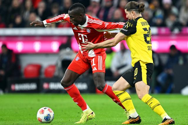 18 October 2025, Bavaria, Munich: Bayern Munich's Nicolas Jackson (L) and Borussia Dortmund's Marcel Sabitzer battle for the ball during the German Bundesliga soccer match between Bayern Munich and Borussia Dortmund at Allianz Arena. Photo: Sven Hoppe/dpa - IMPORTANT NOTICE: DFL and DFB regulations prohibit any use of photographs as image sequences and/or quasi-video.