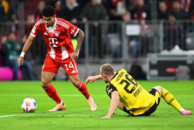 18 October 2025, Bavaria, Munich: Bayern Munich's Luis Diaz (L) and Borussia Dortmund's Julian Ryerson battle for the ball during the German Bundesliga soccer match between Bayern Munich and Borussia Dortmund at Allianz Arena. Photo: Sven Hoppe/dpa - IMPORTANT NOTICE: DFL and DFB regulations prohibit any use of photographs as image sequences and/or quasi-video.