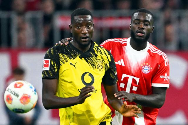 18 October 2025, Bavaria, Munich: Bayern Munich's Dayot Upamecano (R) and Borussia Dortmund's Serhou Guirassy battle for the ball during the German Bundesliga soccer match between Bayern Munich and Borussia Dortmund at Allianz Arena. Photo: Sven Hoppe/dpa - IMPORTANT NOTICE: DFL and DFB regulations prohibit any use of photographs as image sequences and/or quasi-video.