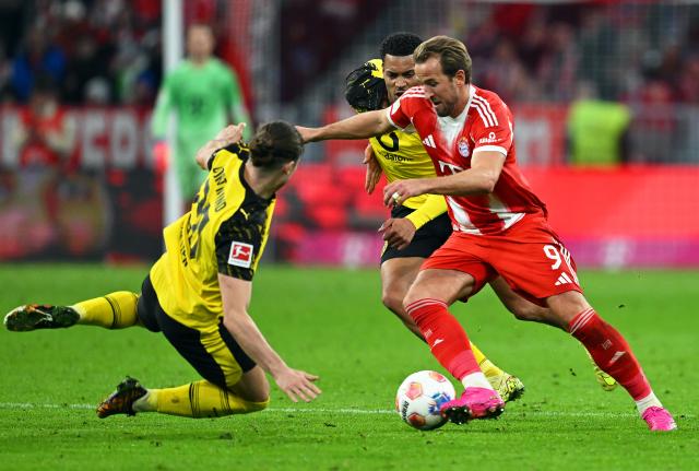 18 October 2025, Bavaria, Munich: Bayern Munich's Harry Kane (R) and Borussia Dortmund's Marcel Sabitzer battle for the ball during the German Bundesliga soccer match between Bayern Munich and Borussia Dortmund at Allianz Arena. Photo: Sven Hoppe/dpa - IMPORTANT NOTICE: DFL and DFB regulations prohibit any use of photographs as image sequences and/or quasi-video.