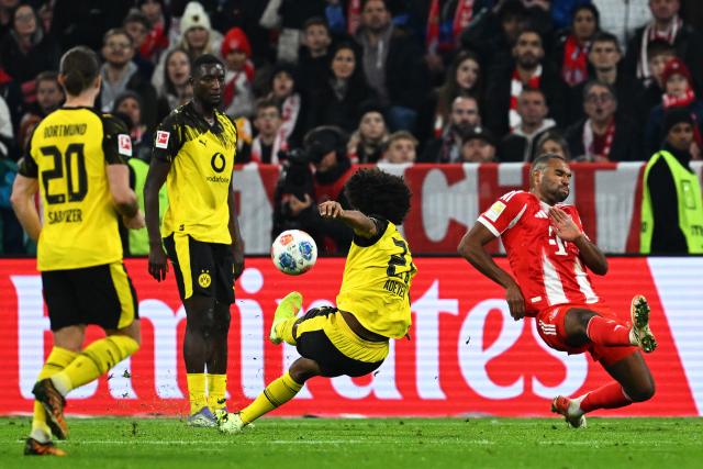 18 October 2025, Bavaria, Munich: Bayern Munich's Jonathan Tah (R) and Borussia Dortmund's Karim Adeyemi battle for the ball during the German Bundesliga soccer match between Bayern Munich and Borussia Dortmund at Allianz Arena. Photo: Sven Hoppe/dpa - IMPORTANT NOTICE: DFL and DFB regulations prohibit any use of photographs as image sequences and/or quasi-video.