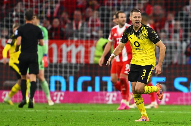 18 October 2025, Bavaria, Munich: Borussia Dortmund'S Waldemar Anton celebrates scoring his side's FIRST goal during the German Bundesliga soccer match between Bayern Munich and Borussia Dortmund at Allianz Arena. Photo: Sven Hoppe/dpa - IMPORTANT NOTICE: DFL and DFB regulations prohibit any use of photographs as image sequences and/or quasi-video.