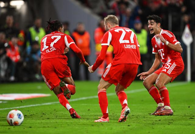 18 October 2025, Bavaria, Munich: Bayern Munich's Michael Olise (L) celebrates scoring his side's second goal with teammates Konrad Laimer (C) and Aleksandar Pavlovic during the German Bundesliga soccer match between Bayern Munich and Borussia Dortmund at Allianz Arena. Photo: Sven Hoppe/dpa - IMPORTANT NOTICE: DFL and DFB regulations prohibit any use of photographs as image sequences and/or quasi-video.