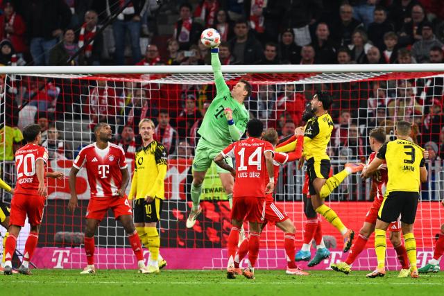 18 October 2025, Bavaria, Munich: Bayern Munich goalkeeper Manuel Neuer (C) clears the ball during the German Bundesliga soccer match between Bayern Munich and Borussia Dortmund at Allianz Arena. Photo: Sven Hoppe/dpa - IMPORTANT NOTICE: DFL and DFB regulations prohibit any use of photographs as image sequences and/or quasi-video.