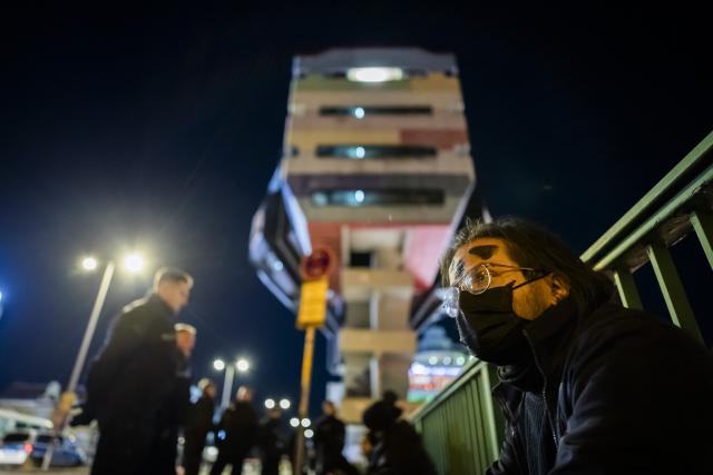 18 October 2025, Berlin: An activist (R) sits in front of the Berlin "Bierpinsel", watched by police officers, after the occupation was broken up by the police. A group of activists on Saturday occupied the iconic Bierpinsel tower in western Berlin, which has stood vacant for years, to protest against empty properties and property speculation in the German capital. Photo: Christoph Soeder/dpa