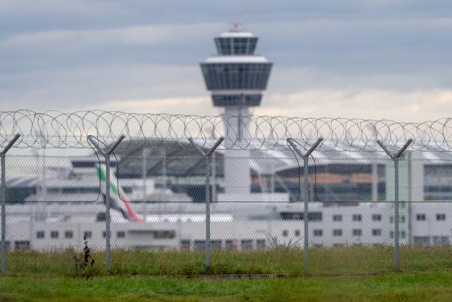 FILED - 04 October 2025, Bavaria, Munich: Barbed wire is attached to the fence on the grounds of Munich Airport. Normal operations have been restored at Munich airport after take-offs and landings were halted briefly on account of "suspicious observations," a spokeswoman for the southern German airport reported on Sunday. Photo: Armin Weigel/dpa