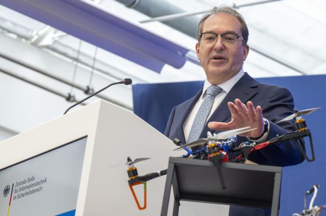 20 October 2025, Bavaria, Munich: German Minister of the Interior Alexander Dobrindt  shows off an FPV self-built drone during Dobrindt's visit to the Central Office for Information Technology in the Security Sector (ZITiS). Photo: Peter Kneffel/dpa