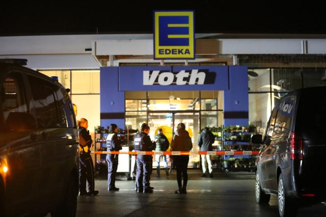20 October 2025, North Rhine-Westphalia, Lemgo: Police officers are deployed outside a supermarket in Lippe district, where a teenager was fatally injured during an altercation. Photo: Christian Müller/dpa