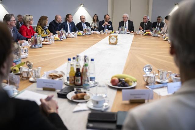 21 October 2025, Baden-Württemberg, Stuttgart: Winfried Kretschmann (4th R), Minister President of Baden-Wuerttemberg, and Germany's Chancellor Friedrich Merz (5th R) sit with members of the Baden-Wuerttemberg Cabinet in the Cabinet Room of Villa Reitzenstein, the seat of the Baden-Wuerttemberg State Ministry, during the Chancellor's inaugural visit to the state. Photo: Marijan Murat/dpa
