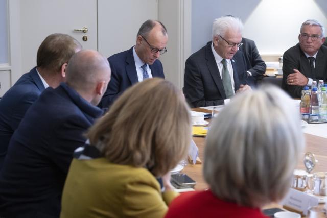 21 October 2025, Baden-Württemberg, Stuttgart: (R-L) Thomas Strobl, Minister of the Interior of Baden-Wuerttemberg, Winfried Kretschmann, Minister President of Baden-Wuerttemberg, and Germany's Chancellor Friedrich Merz sit with members of the Baden-Wuerttemberg Cabinet in the Cabinet Room of Villa Reitzenstein, the seat of the Baden-Wuerttemberg State Ministry, during the Chancellor's inaugural visit to the state. Photo: Marijan Murat/dpa