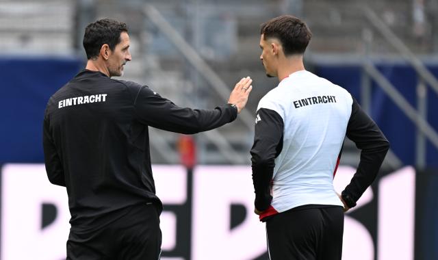 21 October 2025, Hesse, Frankfurt/Main: Eintracht Frankfurt coach Dino Toppmoeller (L) talks to Robin Koch during the final training session ahead of Wednesday's UEFA Champions League soccer match against Liverpool FC. Photo: Arne Dedert/dpa