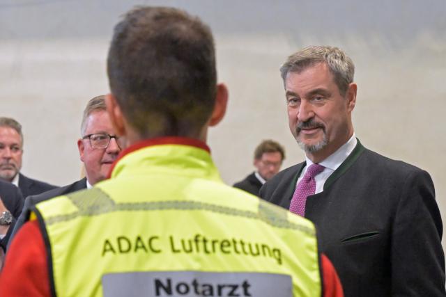 PRODUCTION - 21 October 2025, Bavaria, Wessling: Markus Soeder, Minister President of Bavaria, speaks with an ADAC Air Rescue emergency doctor at the celebration of the 55th anniversary of the air rescue service and the inauguration of the new ADAC Air Rescue Campus at the special airport in Oberpfaffenhofen. Photo: Malin Wunderlich/dpa