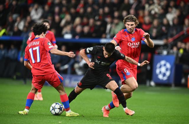 21 October 2025, North Rhine-Westphalia, Leverkusen: (L-R)Paris St. Germain's Vitinha, Leverkusen's Claudio Echeverri and Paris St. Germain's Illya Zabarnyi battle for thr ball during the UEFA Champions League soccer match match between Bayer Leverkusen and Paris Saint-Germain at BayArena. Photo: Bernd Thissen/dpa