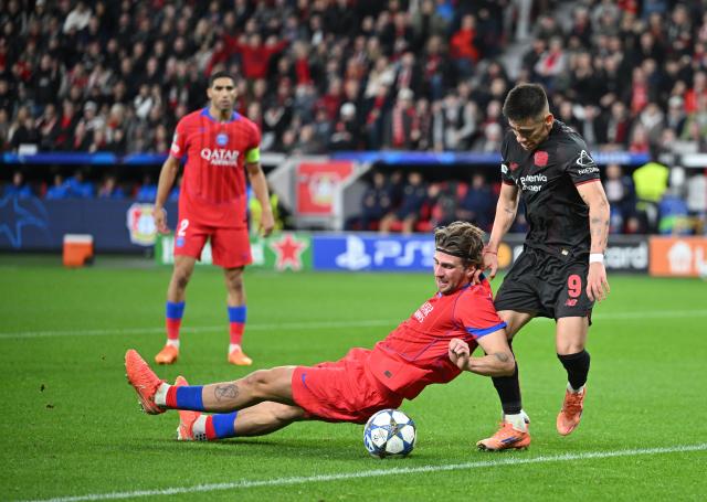 21 October 2025, North Rhine-Westphalia, Leverkusen: Paris St. Germain's Illya Zabarnyi (L) and Leverkusen's Claudio Echeverri battle for the ball during the UEFA Champions League soccer match between Bayer Leverkusen and Paris Saint-Germain at BayArena. Photo: Bernd Thissen/dpa
