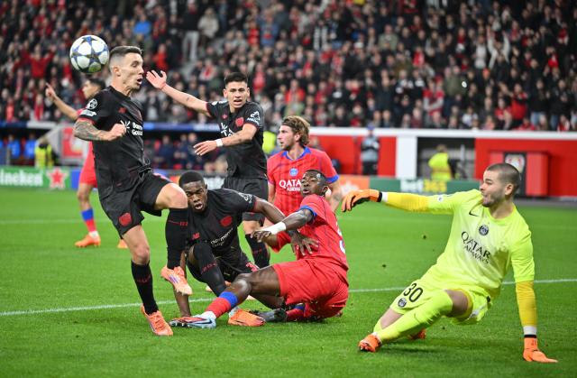 21 October 2025, North Rhine-Westphalia, Leverkusen: Turbulent scene in front of the goal by Paris St. Germain goalkeeper Lucas Chevalier (r) during the UEFA Champions League soccer match between Bayer Leverkusen and Paris Saint-Germain at BayArena. Photo: Bernd Thissen/dpa