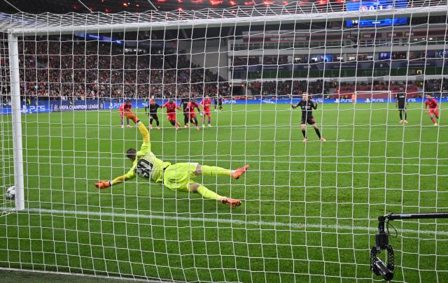 21 October 2025, North Rhine-Westphalia, Leverkusen: Leverkusen's Alejandro Grimaldo (r) misses a penalty against Paris Saint-Germain goalkeeper Lucas Chevalier during the UEFA Champions League soccer match between Bayer Leverkusen and Paris Saint-Germain at BayArena. Photo: Bernd Thissen/dpa