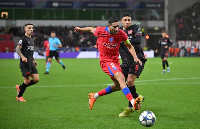 21 October 2025, North Rhine-Westphalia, Leverkusen: Paris St. Germain's Achraf Hakimi (L) and Leverkusen's Ezequiel Fernandez battle for the ball during the UEFA Champions League soccer match between Bayer Leverkusen vs Paris Saint-Germain. Photo: Bernd Thissen/dpa