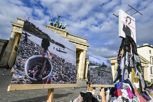 22 October 2025, Berlin: The environmental organization Greenpeace stages a protest against the fast fashion trend with a five-metre-high installation in front of the Brandenburg Gate. The activists are calling for an anti-fast fashion law. Photo: Jens Kalaene/dpa