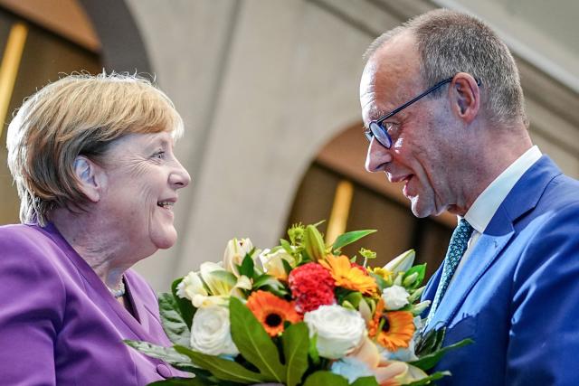 FILED - 25 September 2024, Berlin: Then Christian Democratic Union of Germany (CDU) federal chairman Friedrich Merz presents Former German Chancellor Angela Merkel with a bouquet of flowers at a special Berlin discussion to mark the former Chancellor's 70th birthday. A party organized by the parliamentary faction of German Chancellor Friedrich Merz to mark his 70th birthday will take place without his predecessor Angela Merkel. Photo: Kay Nietfeld/dpa