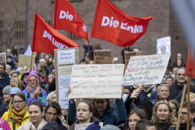 23 October 2025, North Rhine-Westphalia, Cologne: People hold placards and flags during a rally against Chancellor Merz's statements on the cityscape and migration in cologne. Photo: Thomas Banneyer/dpa