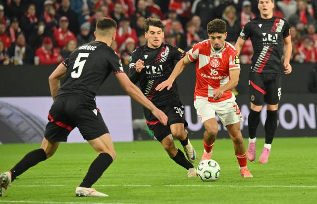 23 October 2025, Rhineland-Palatinate, Mainz: FSV Mainz's Ben Bobzien, Zrinjski Mostar's Ilija Masic and Neven Durasek in action during the UEFA Europa Conference League match between FSV Mainz 05 and Zrinjski Mostar at Mewa Arena. Photo: Torsten Silz/dpa