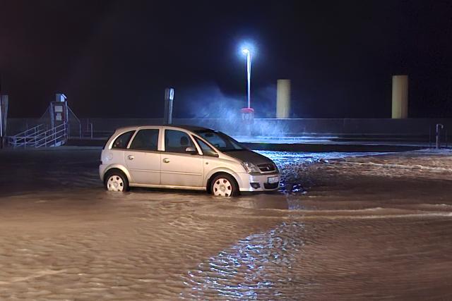 24 October 2025, Lower Saxony, Wilhelmshaven: A car is partially submerged in a flooded parking lot. Photo: Kai Moorschlatt/dpa