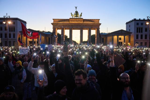 FILED - 19 October 2025, Berlin: Demonstrators hold up their cell phones with flashlights in front of the Brandenburg Gate during a demonstration under the slogan "Brandmauer hoch! We are the cityscape" after a statement made by Chancellor Merz in connection with migration policy. Photo: Annette Riedl/dpa